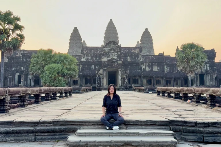 Woman practicing mindfulness meditation in front of Angkor Wat, Cambodia, at dawn — hero image for The Wholehearted Woman Retreat by Vigeo Retreats