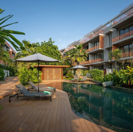 Tui-Blue-Angkor-Grace-Wellness-Resort-Luxury-resort-swimming-pool-with-lounge-chairs-and-tropical-palm-trees-at-a-Vigeo-Retreats-wellness-and-sports-accommodation-venue