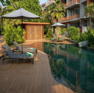 Tui Blue Angkor Grace Wellness Resort Luxury resort swimming pool with lounge chairs and tropical palm trees at a Vigeo Retreats wellness and sports accommodation venue